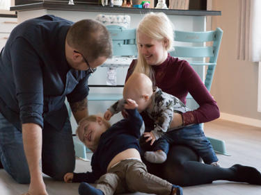 Bilde av barnefamilie som leker på gulvet i sitt nye Älvsbyhus