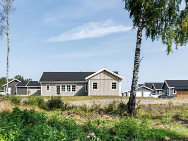 Bilde av en husmodell på et tomtefelt